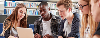 Students in the library browsing a laptop