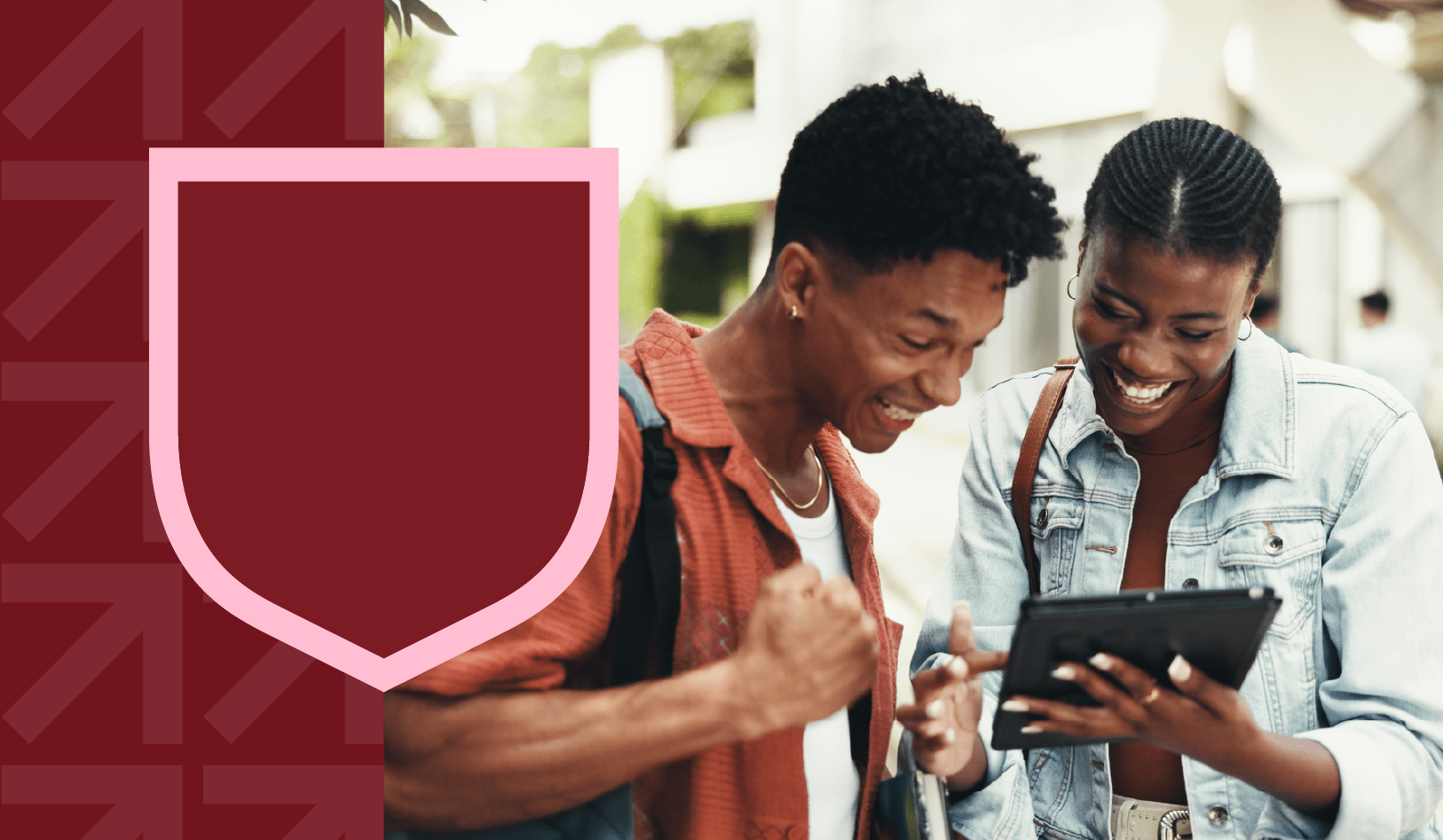 Two students looking on a tablet smiling