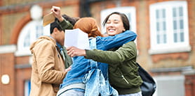 Students in a group hug celebrating