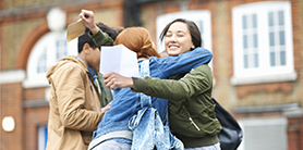 Students in a group hug celebrating
