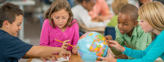 Students viewing a globe in classroom