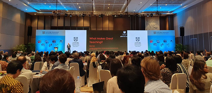 Delegates in a large conference hall watching a presentation