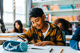 Student in the classroom writing notes